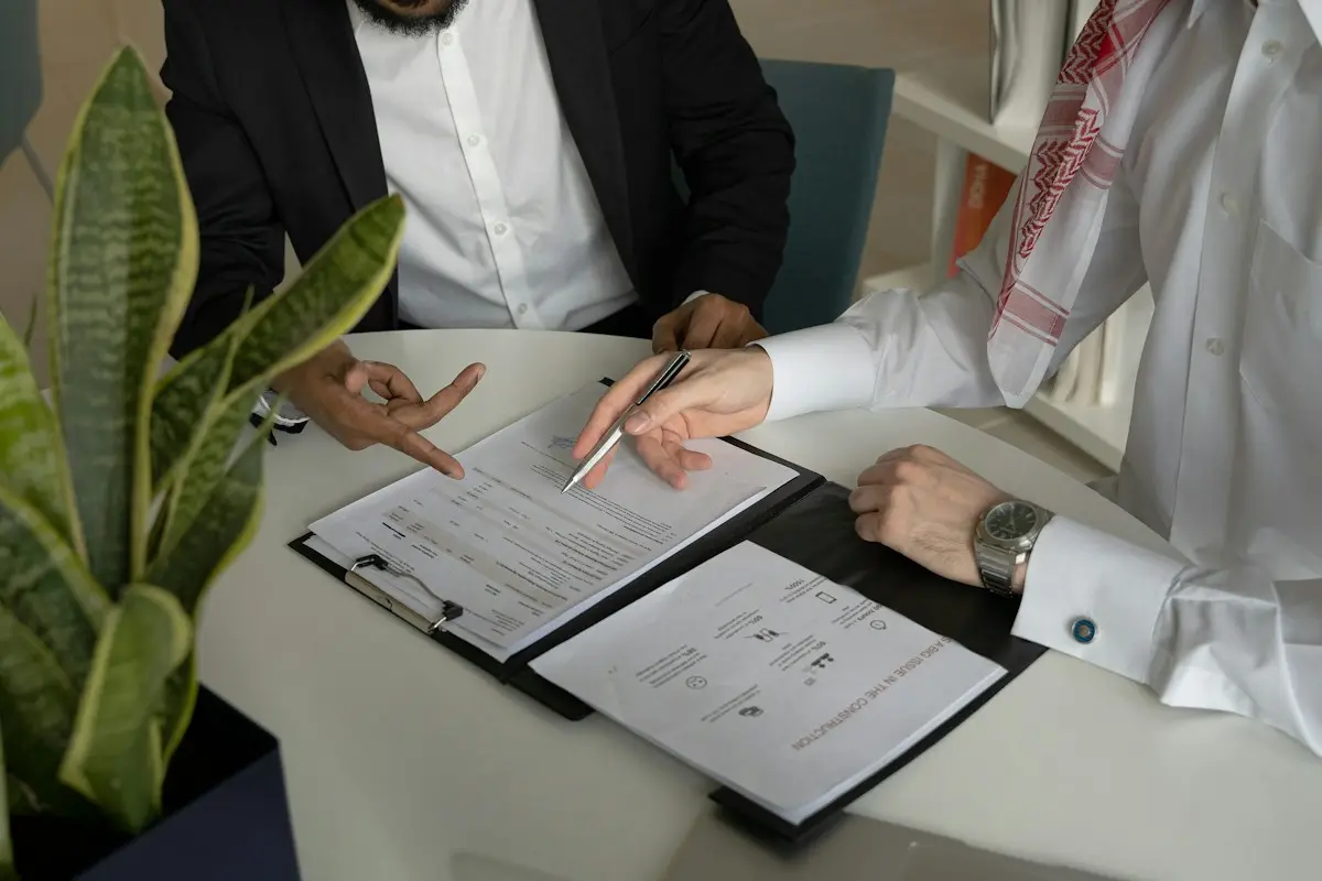 Empresario y graduado social firmando un contrato de trabajo en el despacho