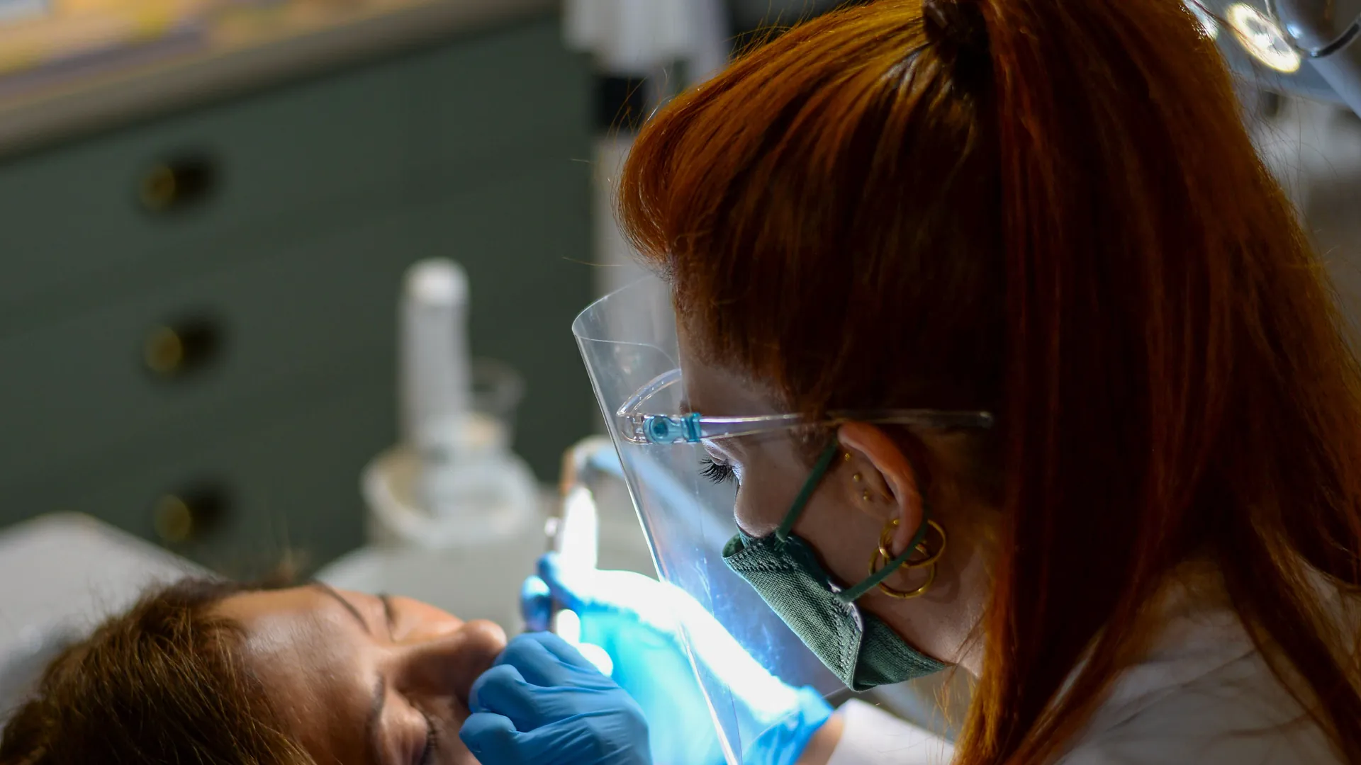 Dentista de Clínica Velia atendiendo a una paciente en el sillón, en nuestra clínica dental del centro de Murcia