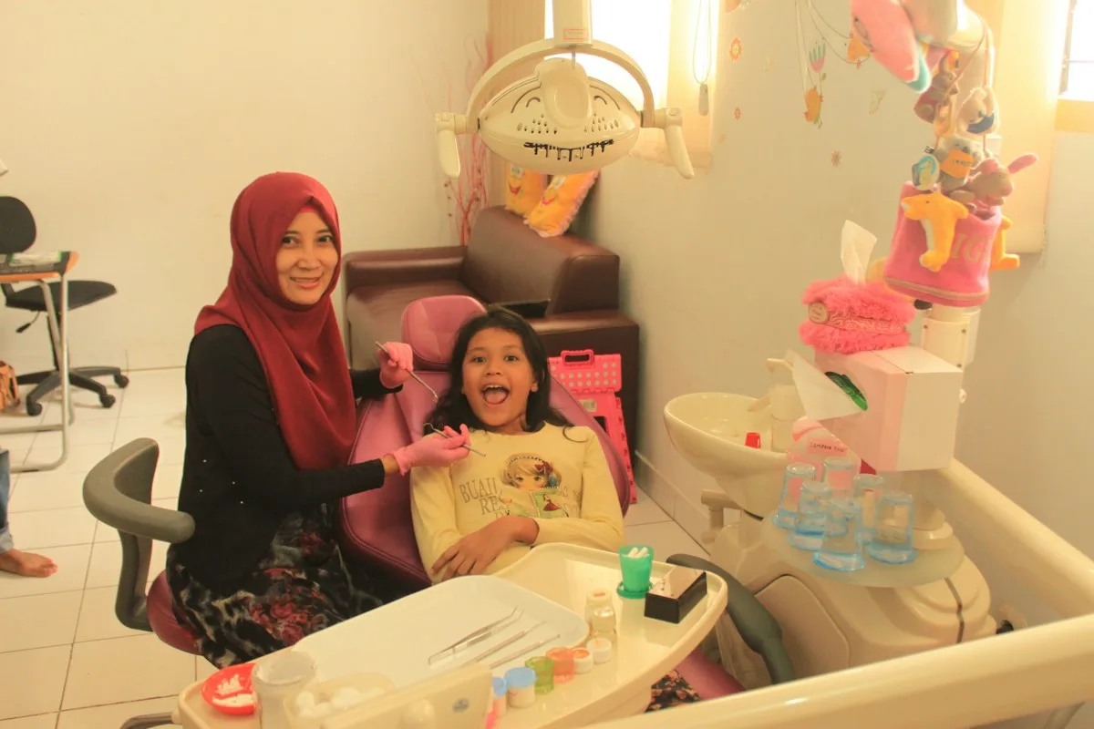 Niña con su madre en la sala dental infantil de Clínica Velia
