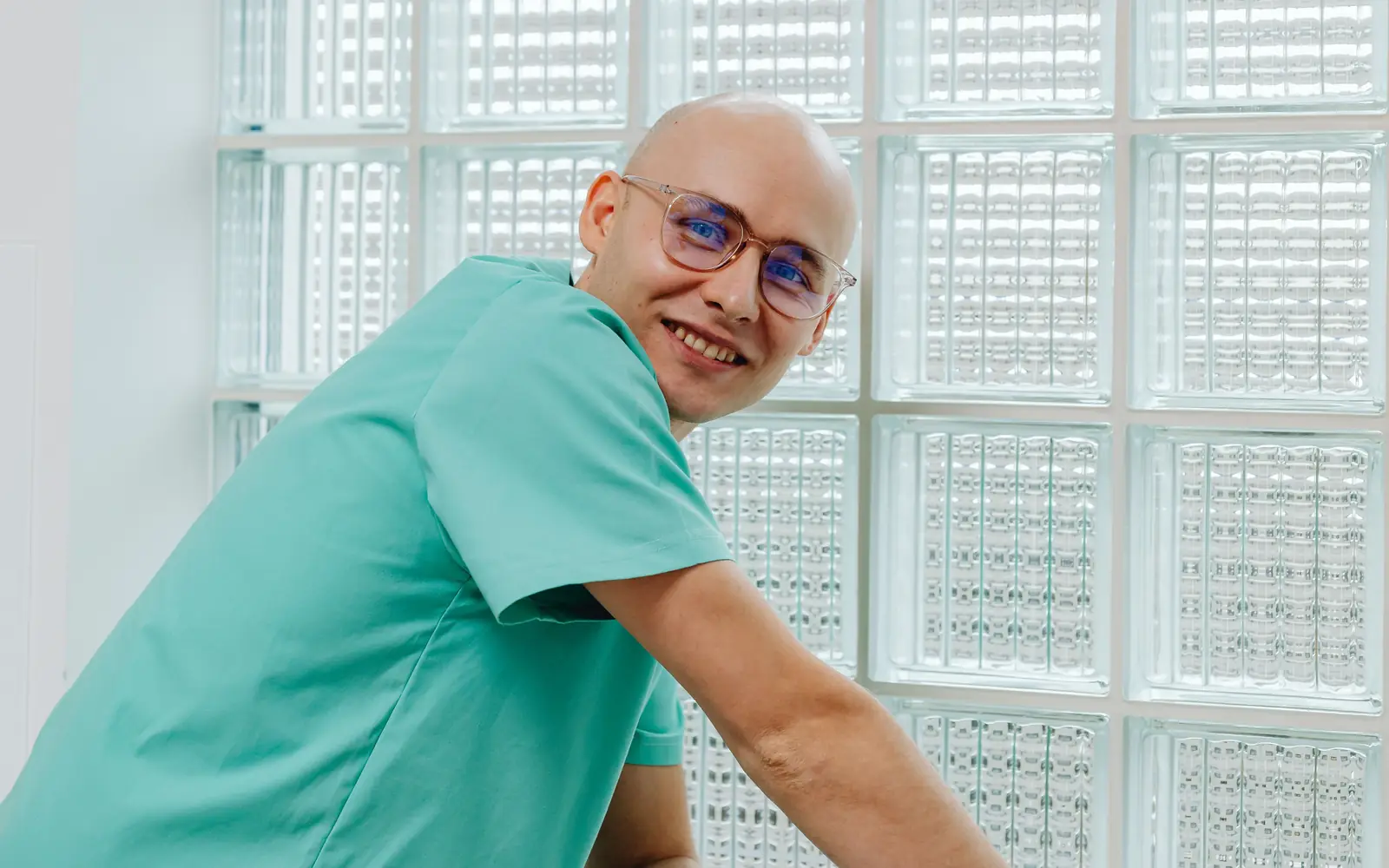 Dentista de la clínica sonriendo en un gabinete luminoso, junto a la ventana