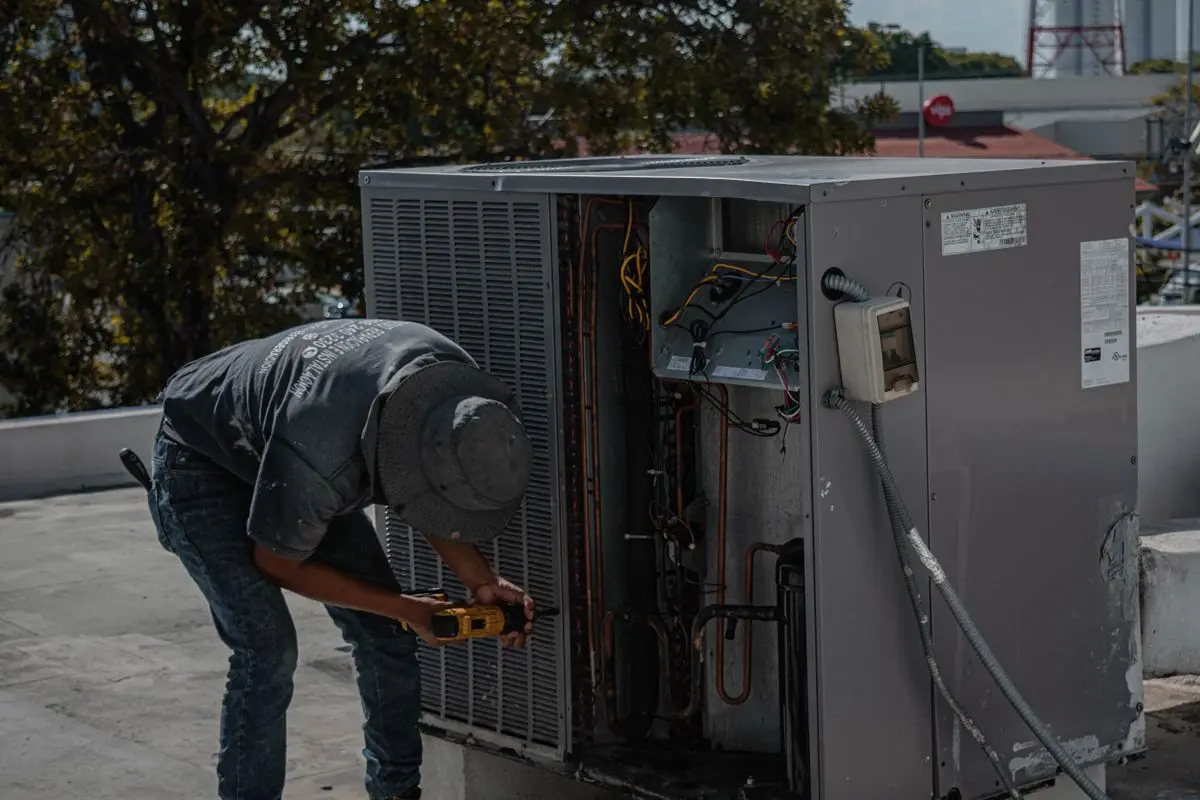 Técnico revisando con manómetros la unidad exterior de un equipo de climatización