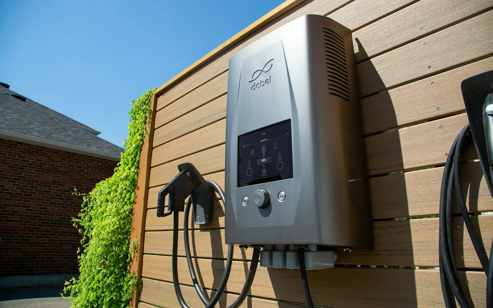 Coche eléctrico cargando en un punto de recarga de pared en el garaje de una vivienda