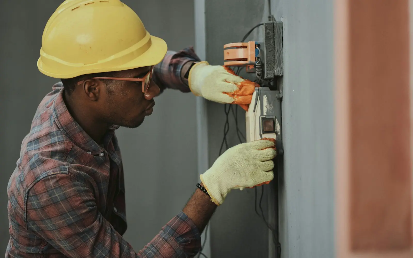 Electricista con linterna frontal revisando de noche el cuadro eléctrico de una vivienda