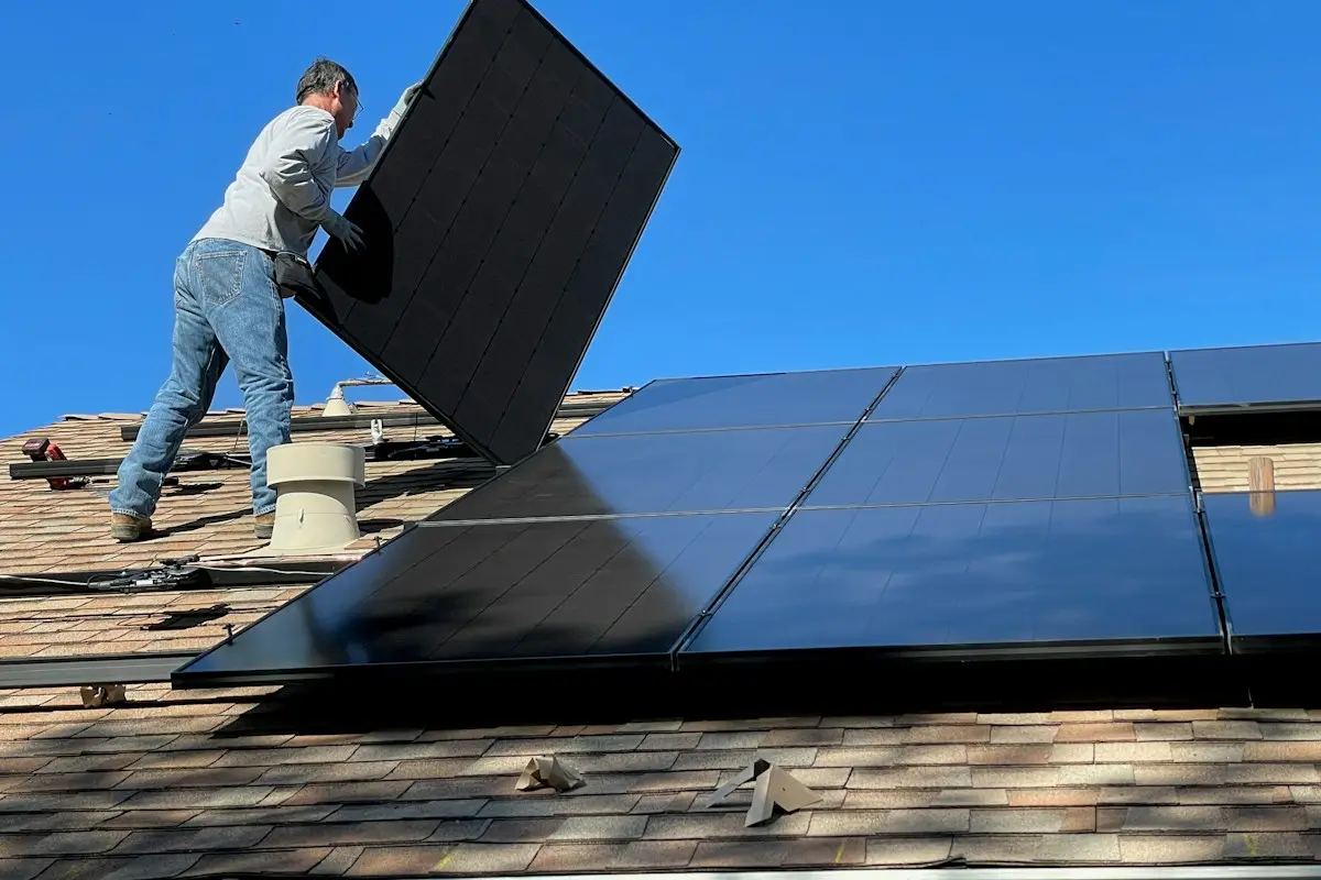 Instaladores colocando placas solares en la azotea de un adosado