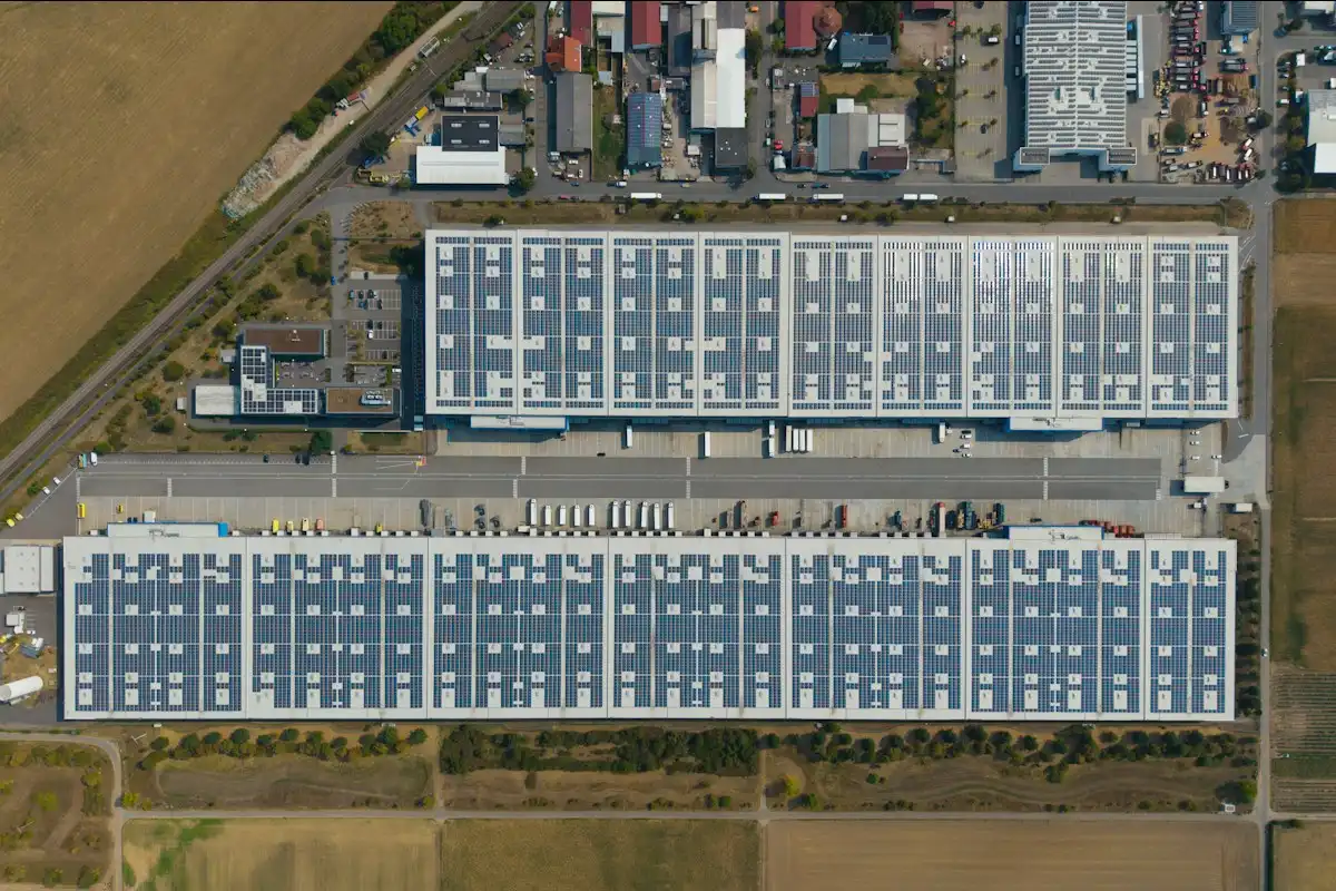 Placas solares en la cubierta de una nave pequeña junto a un taller