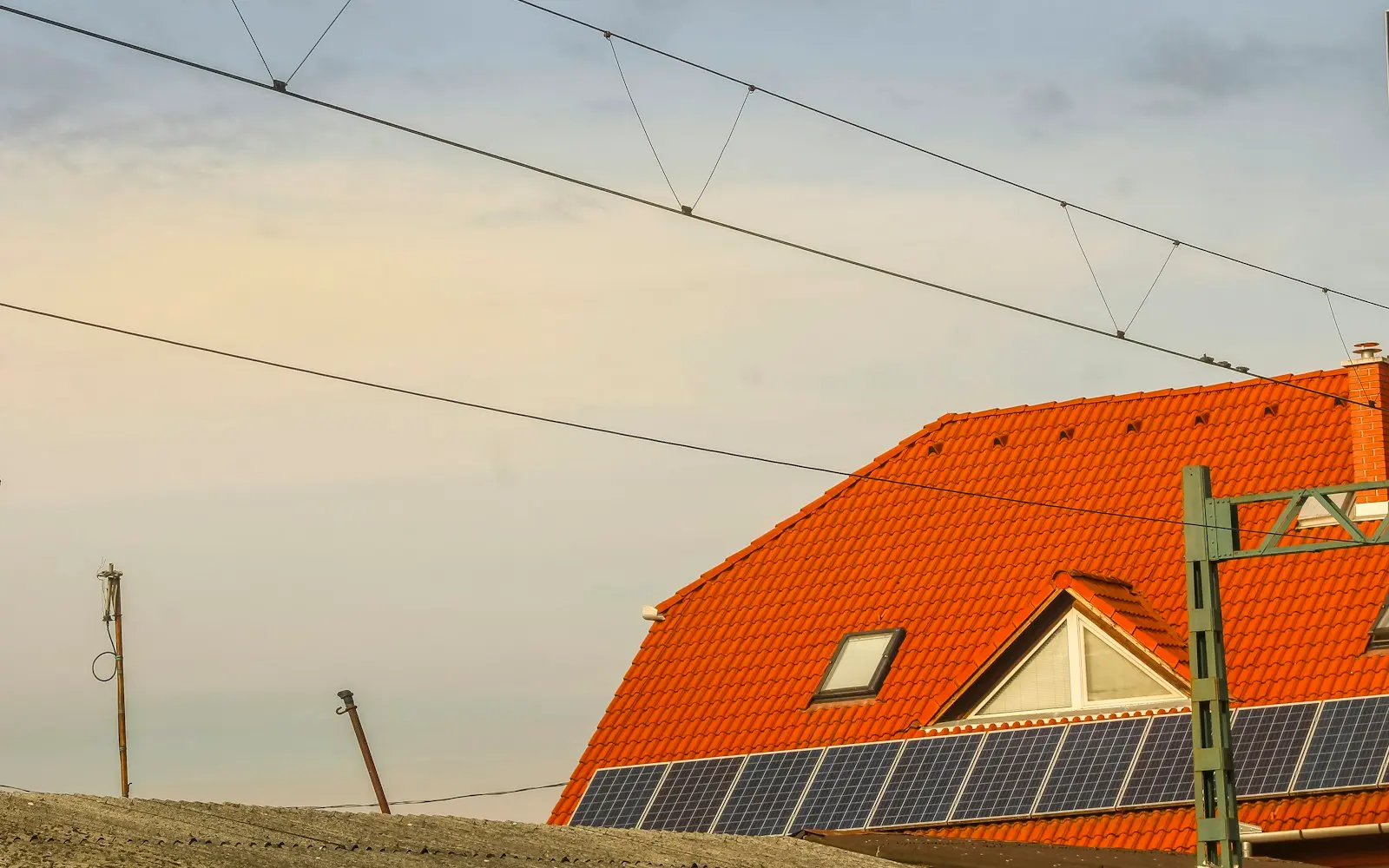 Placas solares negras sobre la cubierta de teja de una casa de la huerta de Murcia, con cielo despejado