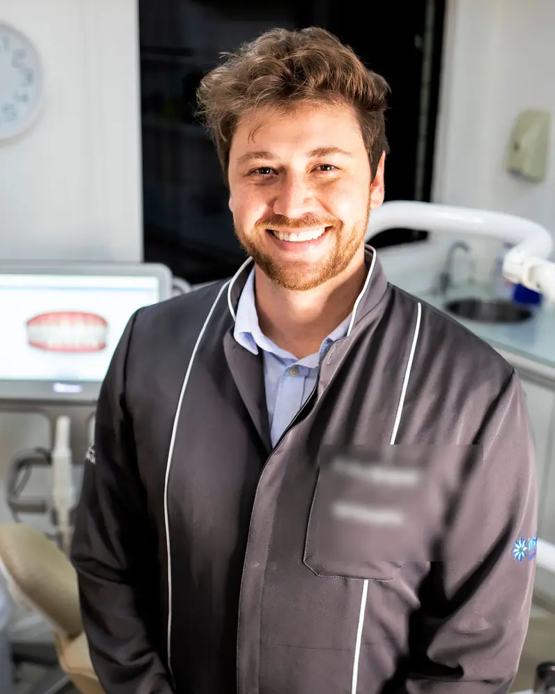 Dentista que se dedica a la ortodoncia sujetando un alineador transparente