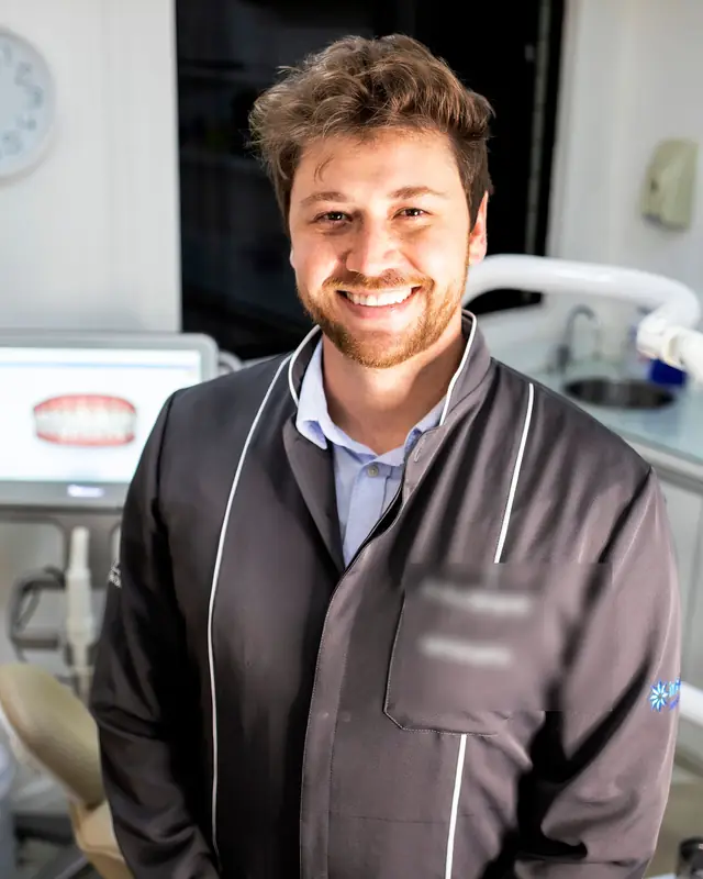 Dentista que se dedica a la ortodoncia, sonriendo en su gabinete