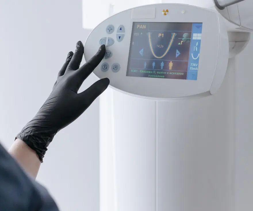 Dentista manejando la pantalla del equipo de diagnóstico 3D de la clínica