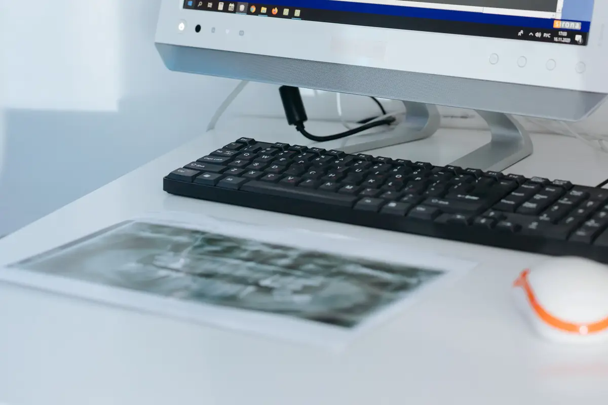 Radiografía dental impresa junto al teclado del ordenador donde se estudia el caso antes de proponer un tratamiento