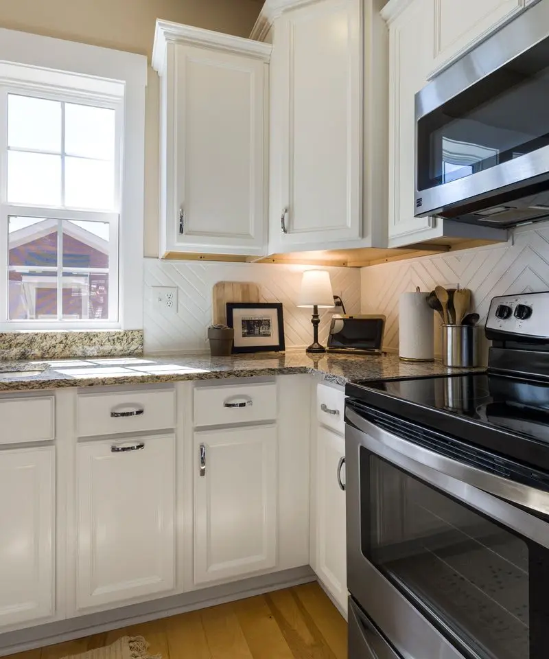 Cocina reformada en una vivienda de Murcia, con muebles blancos y encimera clara