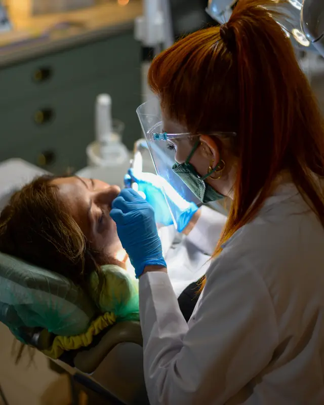 Dentista atendiendo a una paciente en el sillón, con luz suave