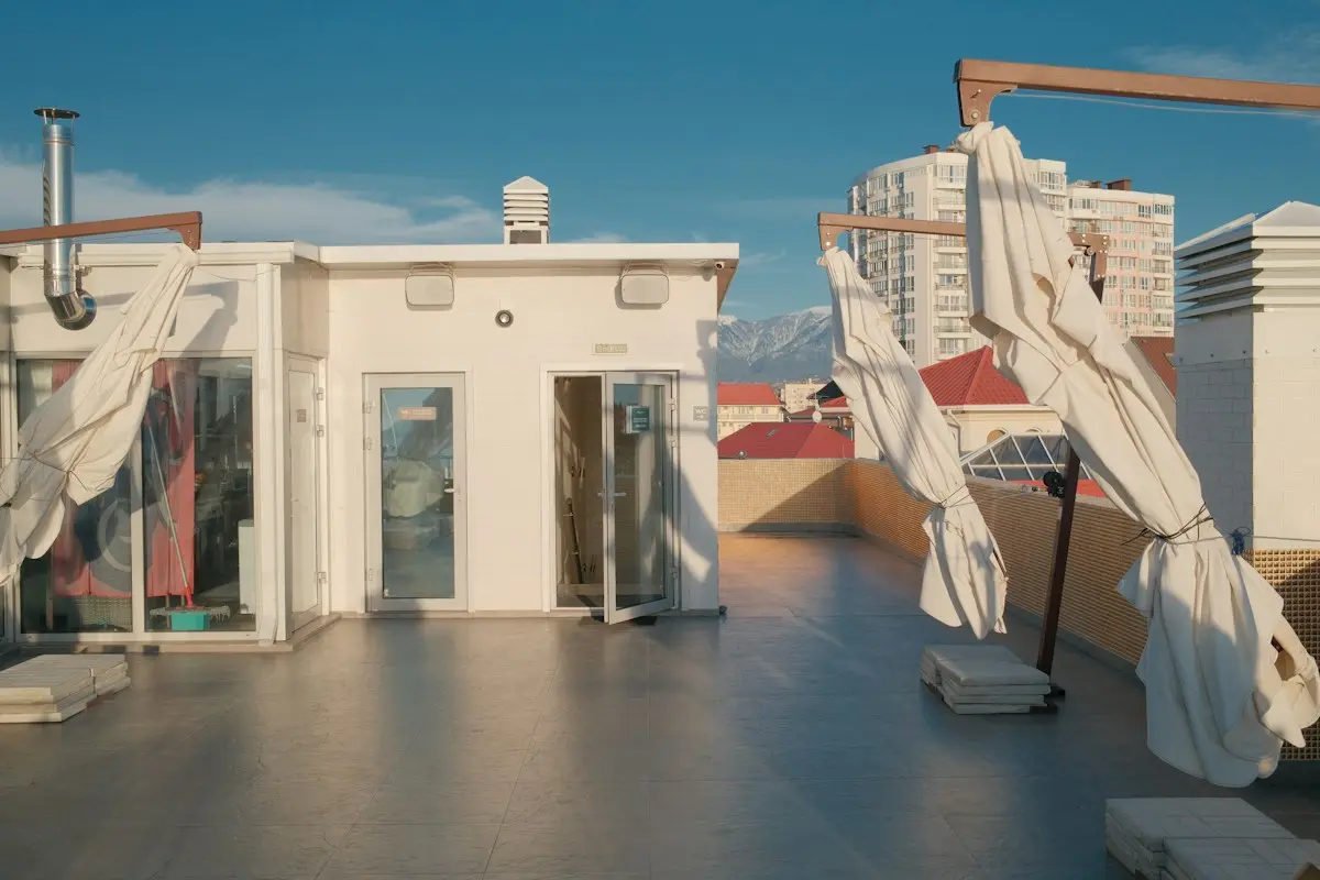 Terraza al oeste con toldo de brazos y toldos verticales laterales bajados